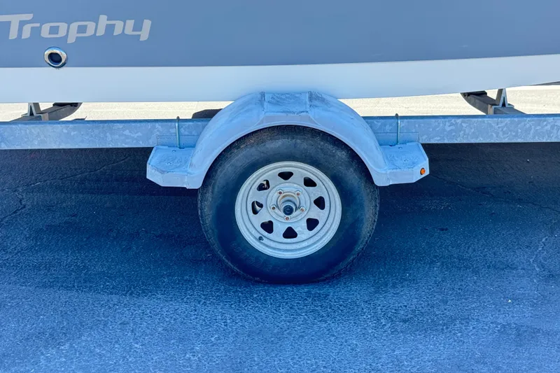 Slide: The Image of Trailer wheel of a 2022 Trophy T18 Bay boat on pavement. - 25