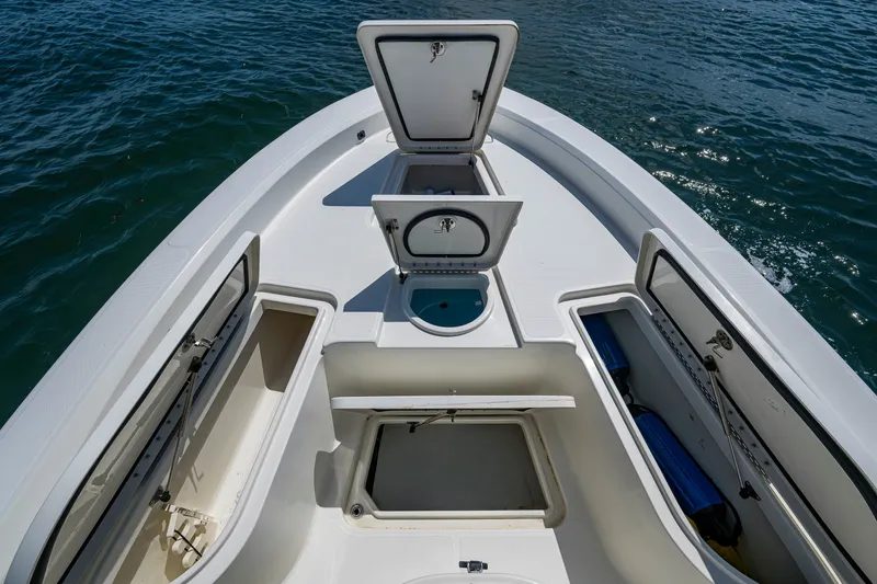 Slide: The Image of 2010 Hydra-Sports Bay Bolt 23 boat with open storage compartments on calm water. - 6