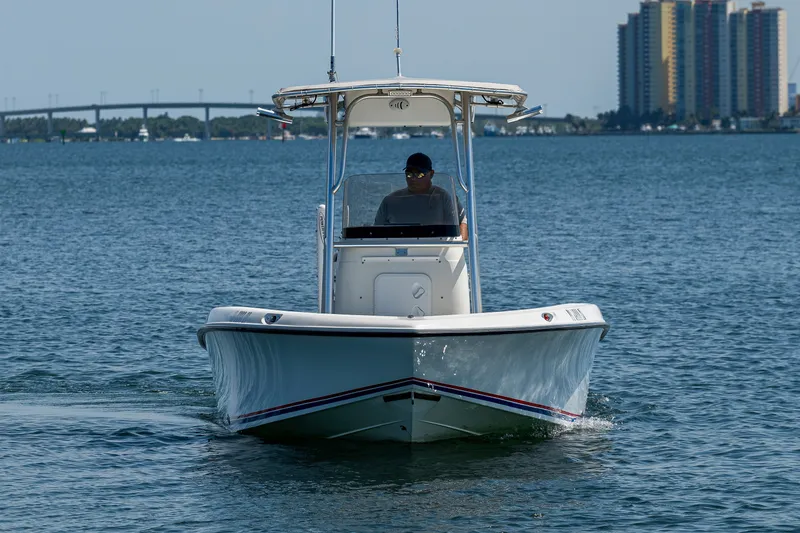 Slide: The Image of 2010 Hydra-Sports Bay Bolt 23 boat cruising on open water with cityscape background. - 3