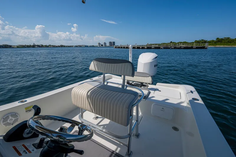 Slide: The Image of 2010 Hydra-Sports Bay Bolt 23 boat on calm water, featuring steering and seating area. - 14