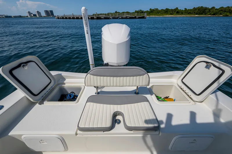 Slide: The Image of 2010 Hydra-Sports Bay Bolt 23 boat with open storage compartments on calm water. - 16