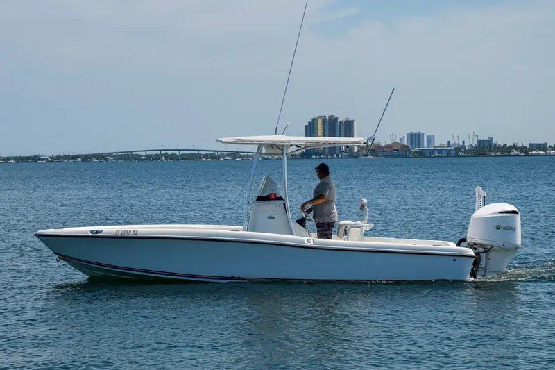 The Image of 2010 Hydra-Sports Bay Bolt 23 boat cruising on calm waters near a city skyline. - 1