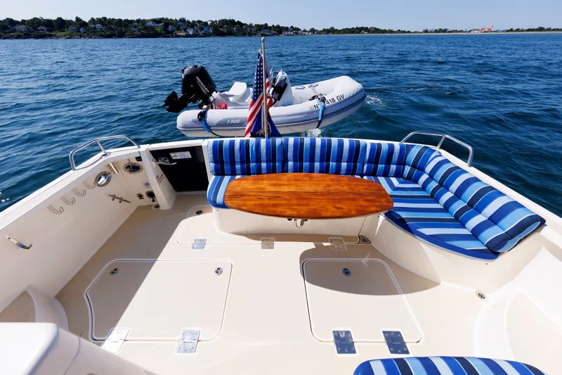 Slide: The Image of 2013 Sabre 42 Salon Express yacht with striped seating and wooden table on open water. - 20