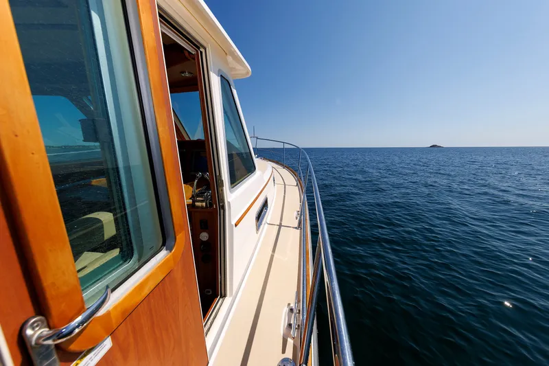 Slide: The Image of 2013 Sabre 42 Salon Express yacht cruising on open sea under clear blue sky. - 17