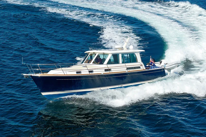 Slide: The Image of 2013 Sabre 42 Salon Express cruising on open water, creating a dynamic wake. - 9