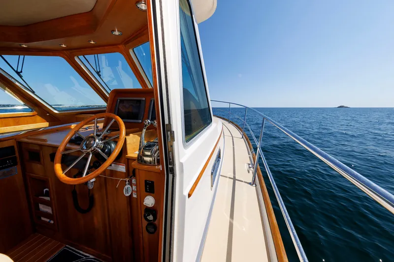 Slide: The Image of 2013 Sabre 42 Salon Express yacht interior with ocean view, featuring wooden helm and steering wheel. - 16