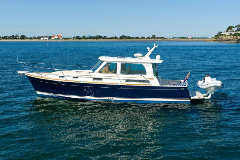 Slide: The Image of 2013 Sabre 42 Salon Express yacht on calm blue water, scenic coastal background. - 2
