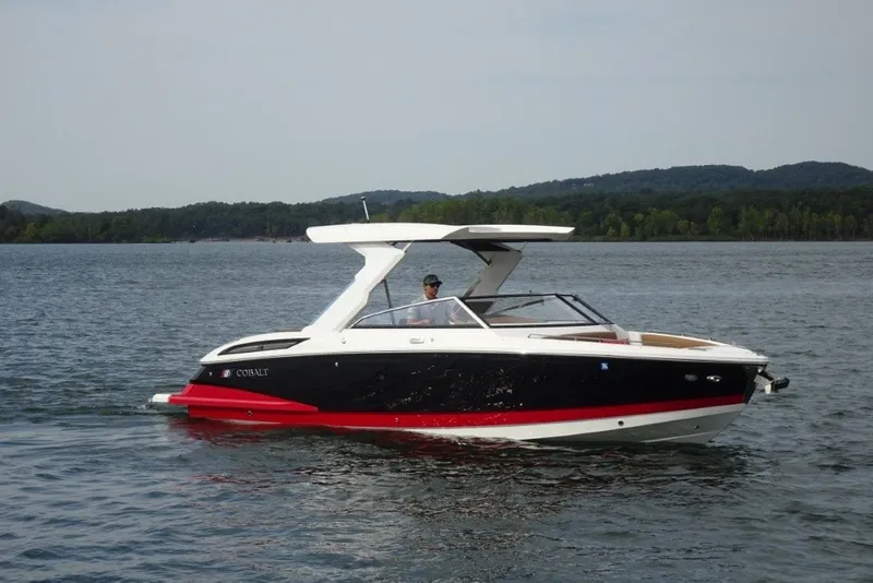 Slide: The Image of 2022 Cobalt A29 boat cruising on a lake with scenic forested hills in the background. - 1