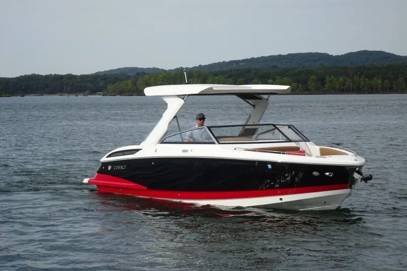 The Image of 2022 Cobalt A29 boat cruising on a lake with scenic forested hills in the background. - 0