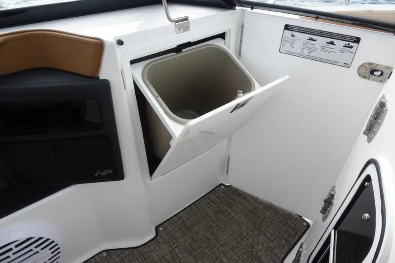 Slide: The Image of 2022 Cobalt A29 boat interior with open storage compartment and trash bin. - 28
