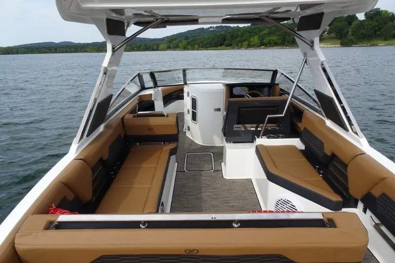 Slide: The Image of 2022 Cobalt A29 boat interior with tan seating on a scenic lake. - 12