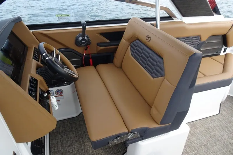 Slide: The Image of Interior of 2022 Cobalt A29 boat with tan and black seating, steering wheel, and controls. - 19