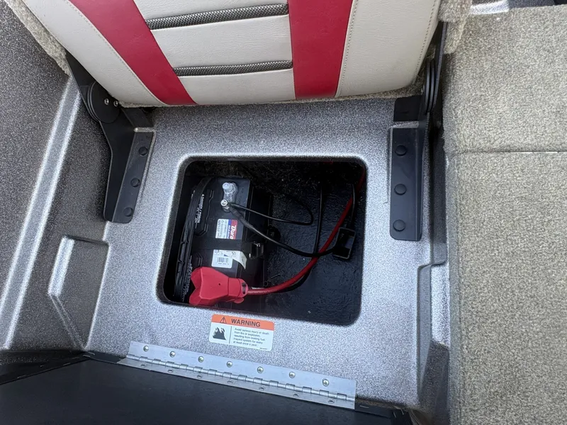 Slide: The Image of A battery compartment under a seat with a battery and cables. - 19