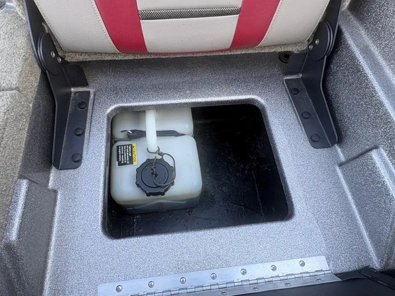 Slide: The Image of An open storage compartment with a white plastic container, surrounded by gray carpeting. - 16