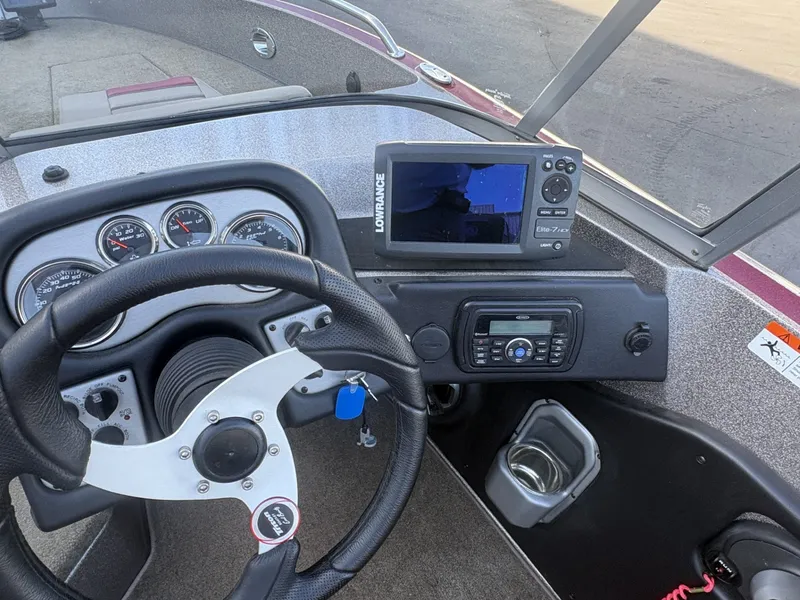Slide: The Image of The image shows the cockpit of a 2014 Triton 192 Allure boat with steering wheel and electronics. - 7
