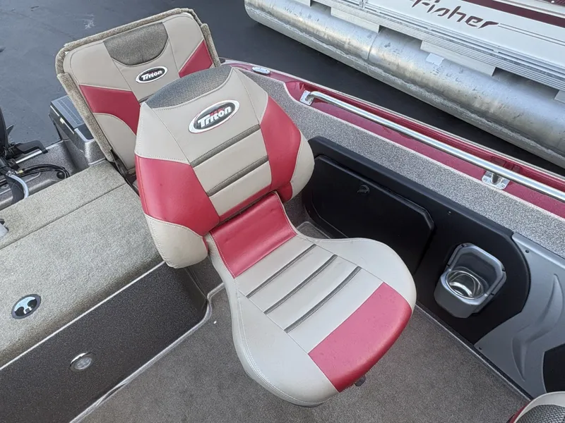 Slide: The Image of A Triton 192 Allure boat seat with red and beige upholstery and Triton logo. - 23