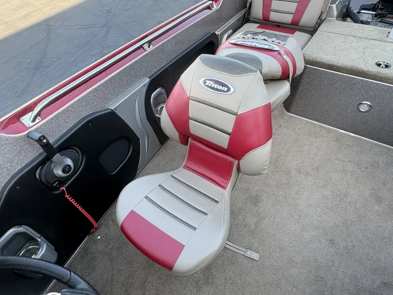Slide: The Image of The interior of a 2014 Triton 192 Allure with red and white seats and gray carpeting. - 21