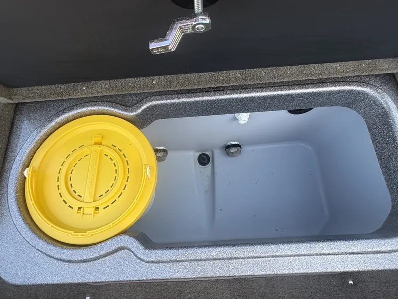 Slide: The Image of An open storage compartment with a yellow lid in a Triton 192 Allure boat. - 13