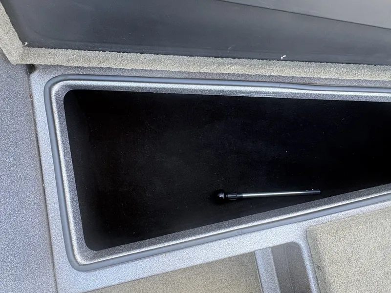 Slide: The Image of An open storage compartment in a boat with a small metal rod inside. - 12