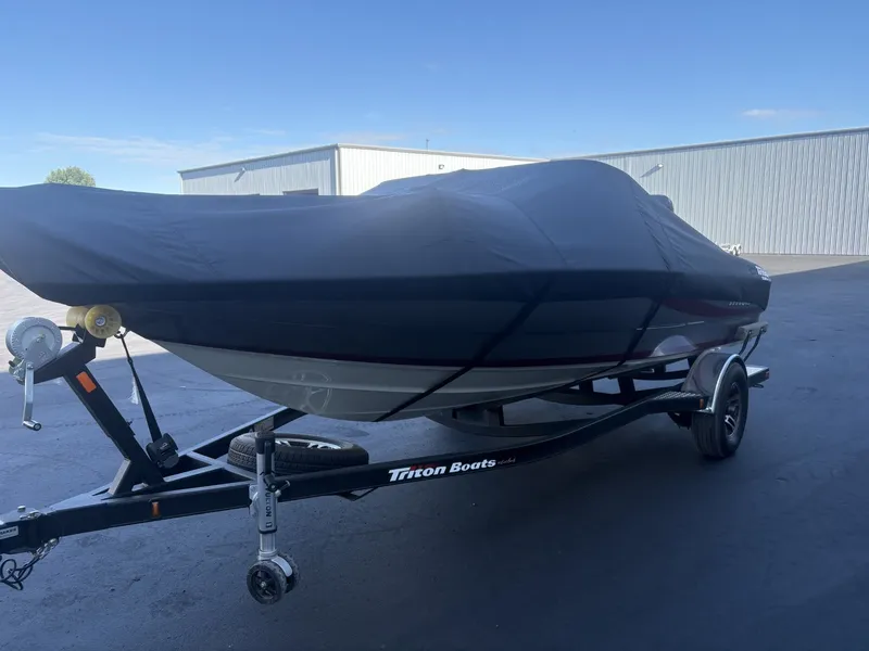 The Image of A 2014 Triton 192 Allure boat on a trailer, covered with a black tarp. - 1