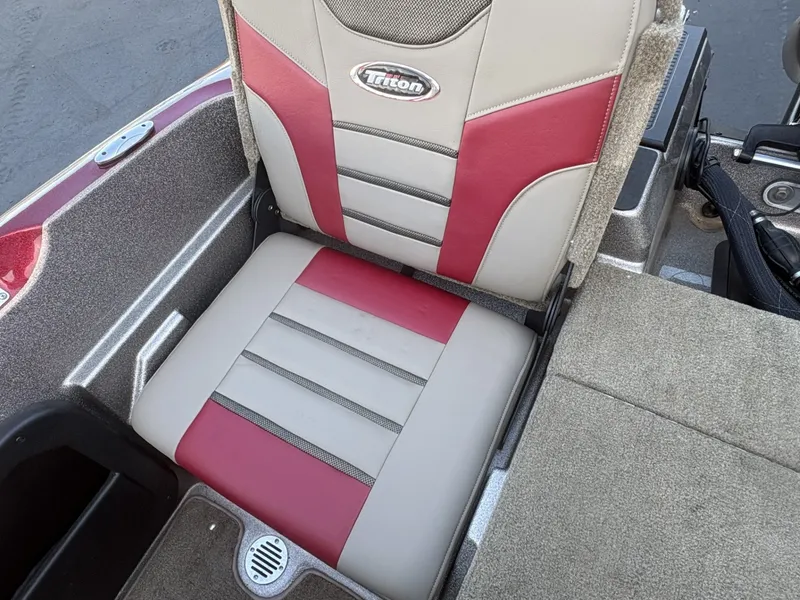 Slide: The Image of A 2014 Triton 192 Allure boat seat with red and beige upholstery and Triton logo. - 17