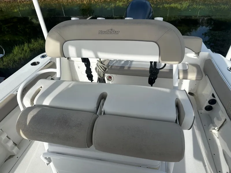 Slide: The Image of 2016 NauticStar 22 XS Offshore boat seating area with cushioned seats and storage. - 22