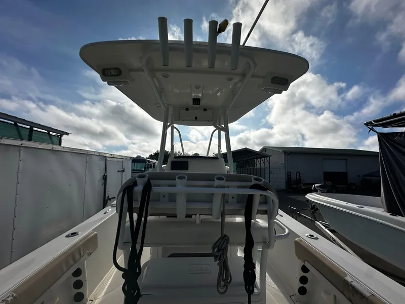 Slide: The Image of 2016 NauticStar 22 XS Offshore boat, view of helm and T-top under cloudy sky. - 25