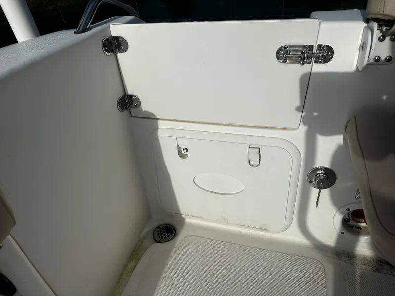 Slide: The Image of 2016 NauticStar 22 XS Offshore boat interior with storage compartment and drain. - 13