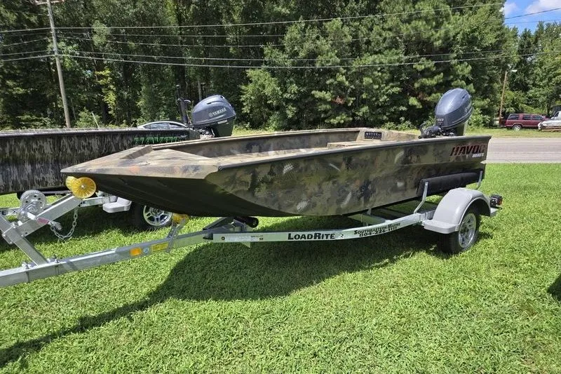 The Image of Camo-patterned 2026 Havoc 1553 VJST boat on LoadRite trailer, parked on grass. - 4
