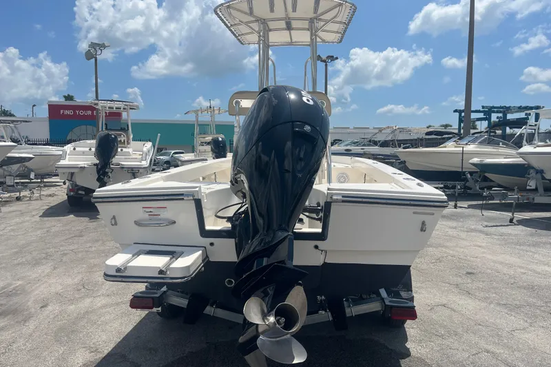 Slide: The Image of Pathfinder 2005 TRS boat with outboard motor, displayed in a sunny marina, 2023 model. - 6