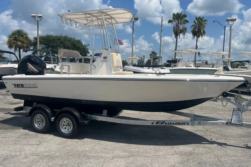 Slide: The Image of 2023 Pathfinder 2005 TRS boat on trailer under clear sky, palm trees in background. - 7