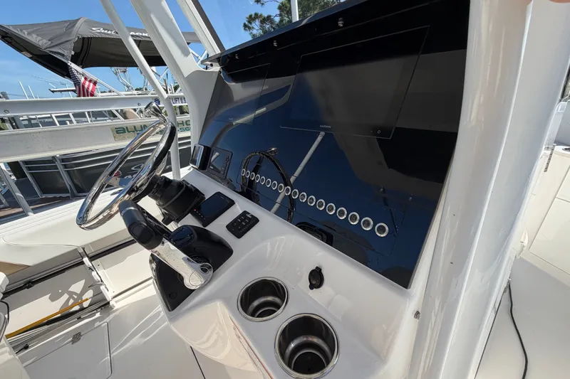 Slide: The Image of Edgewater 262CC 2020 boat dashboard with steering wheel and control panel. - 9