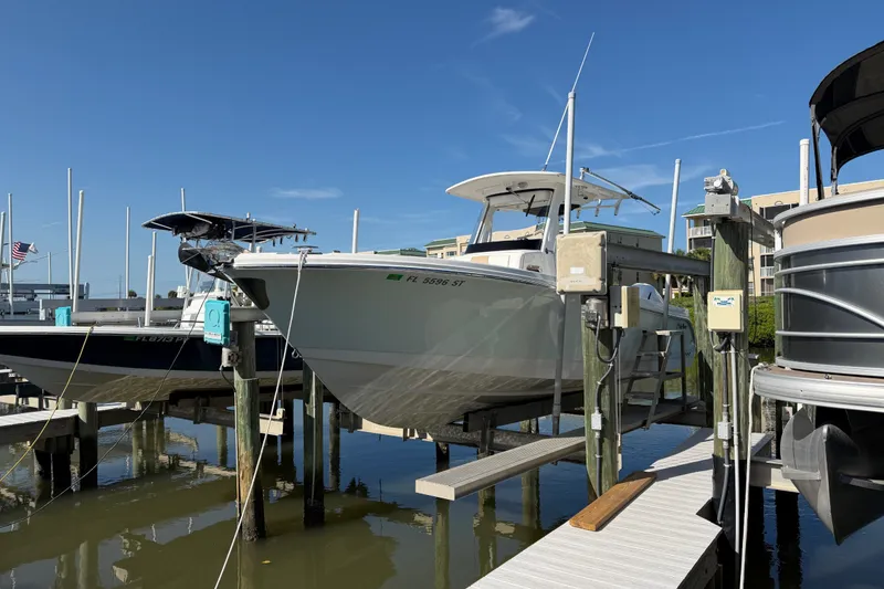 The Image of 2020 Edgewater 262CC boat docked at marina under clear blue sky. - 1