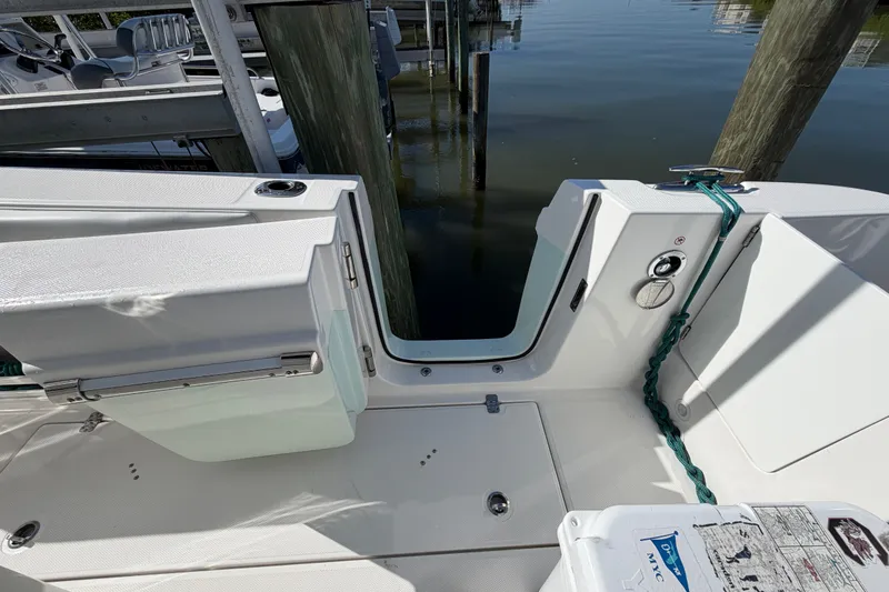 Slide: The Image of Edgewater 262CC 2020 boat interior with open transom door and dock view. - 19