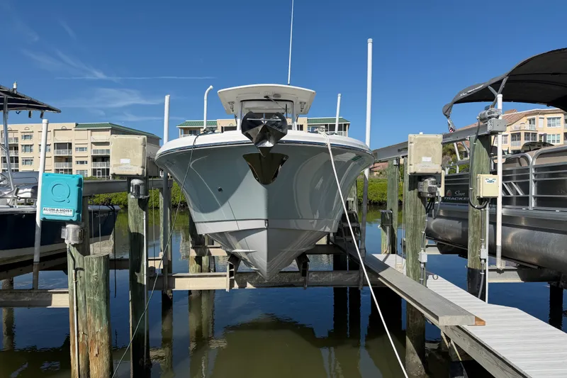 Slide: The Image of 2020 Edgewater 262CC boat docked at marina with clear blue sky. - 2