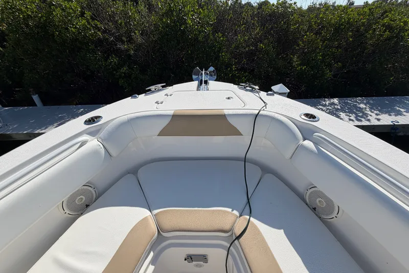 Slide: The Image of Bow seating area of a 2020 Edgewater 262CC boat, featuring cushioned seats and speakers. - 24