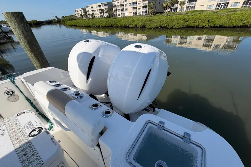 Slide: The Image of Edgewater 262CC 2020 boat with dual outboard motors docked by calm waters. - 16