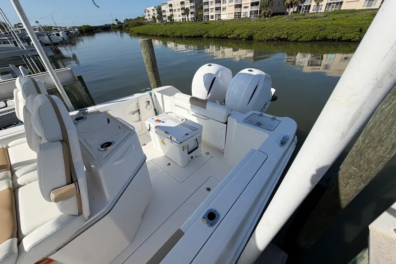 Slide: The Image of 2020 Edgewater 262CC boat docked, featuring dual engines and spacious seating area. - 6