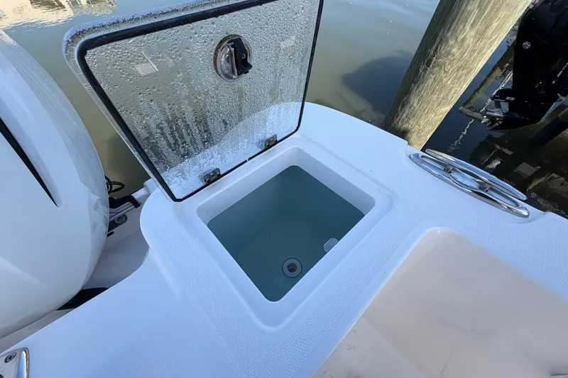 Slide: The Image of Open storage compartment on 2020 Edgewater 262CC boat, docked by water. - 15