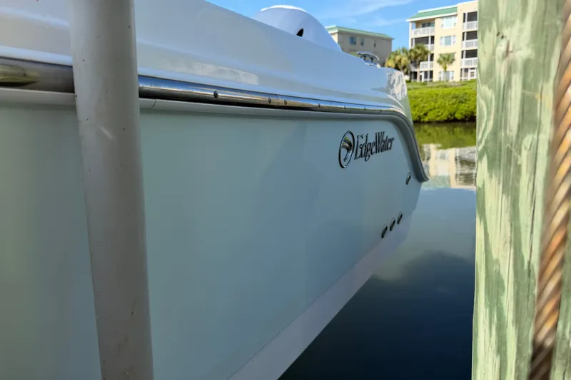 Slide: The Image of 2020 Edgewater 262CC boat docked near waterfront buildings. - 26