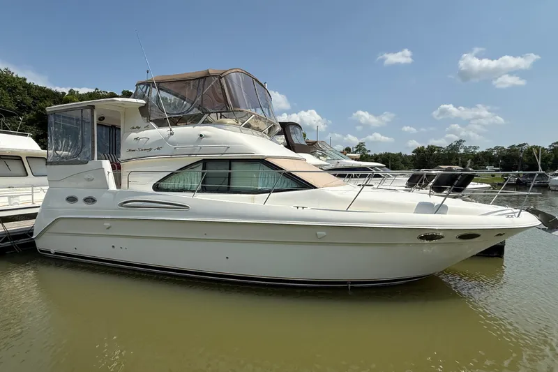 Slide: The Image of 1997 Sea Ray 370 Aft Cabin yacht docked on calm water under a clear sky. - 2