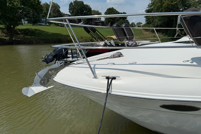 Slide: The Image of 1997 Sea Ray 370 Aft Cabin yacht anchored on a calm river with lush greenery. - 8