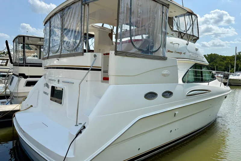 Slide: The Image of 1997 Sea Ray 370 Aft Cabin yacht docked at marina under clear skies. - 4