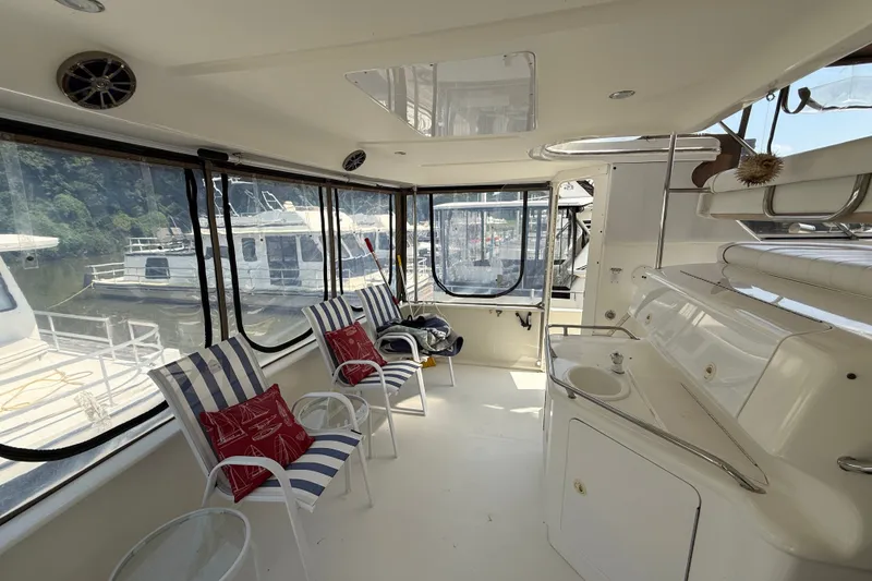 Slide: The Image of 1997 Sea Ray 370 Aft Cabin interior with striped chairs and marina view. - 15