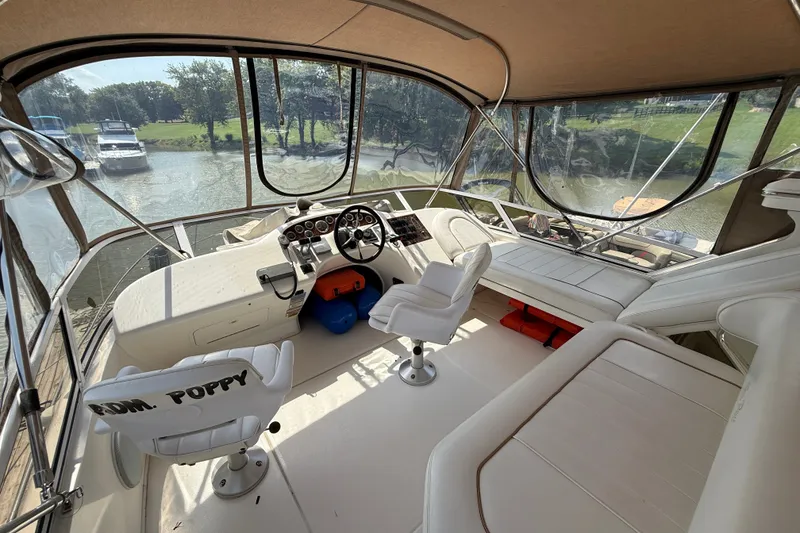 Slide: The Image of 1997 Sea Ray 370 Aft Cabin helm with white seating and panoramic windows. - 18