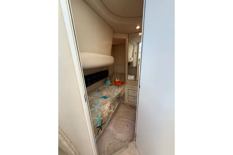 Slide: The Image of 1997 Sea Ray 370 Aft Cabin interior with cozy bed and nautical decor. - 41