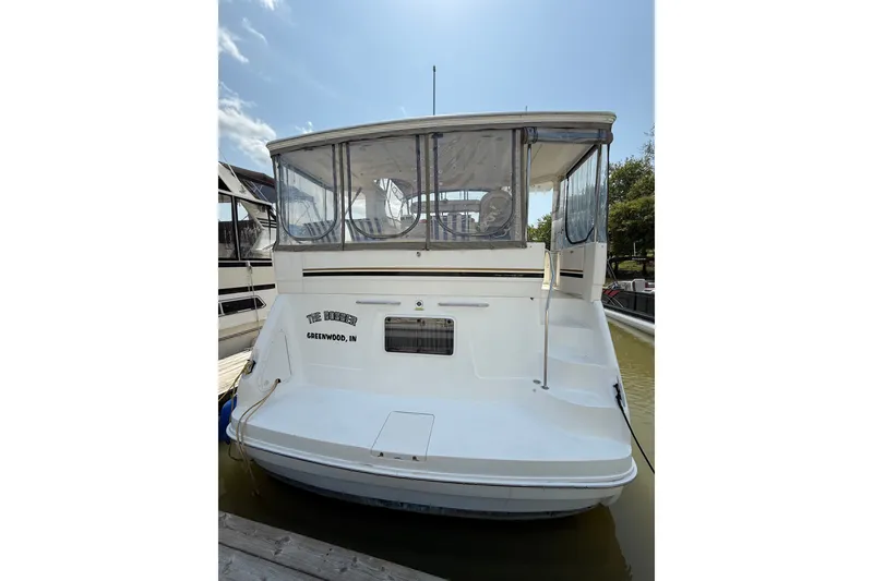 Slide: The Image of 1997 Sea Ray 370 Aft Cabin boat docked, rear view with enclosed deck. - 5