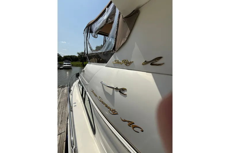 Slide: The Image of 1997 Sea Ray 370 Aft Cabin yacht docked by a serene waterfront. - 11