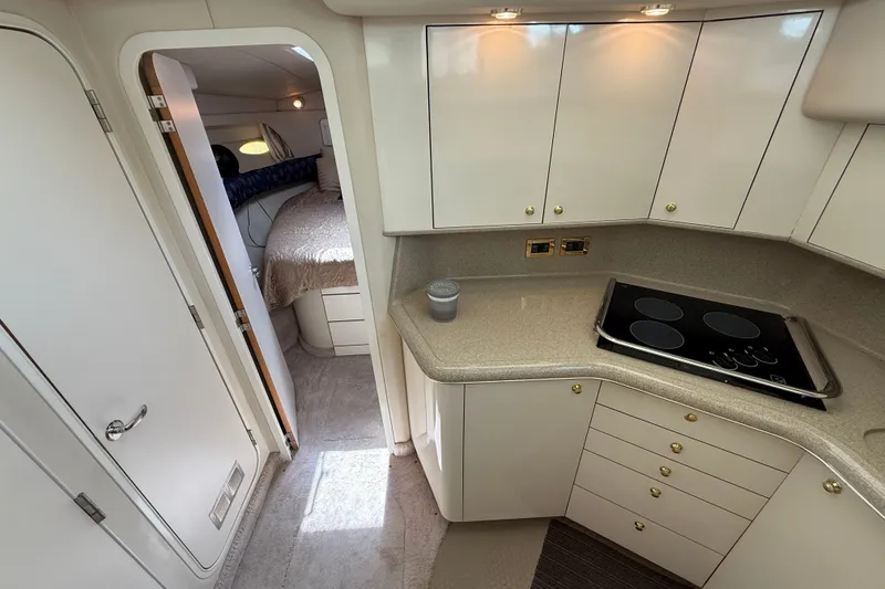 Slide: The Image of 1997 Sea Ray 370 Aft Cabin interior with modern kitchen and cozy bedroom. - 30