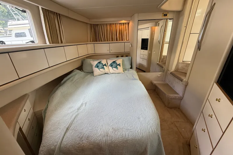 Slide: The Image of Cozy bedroom interior of 1997 Sea Ray 370 Aft Cabin yacht with elegant bedding and storage. - 48